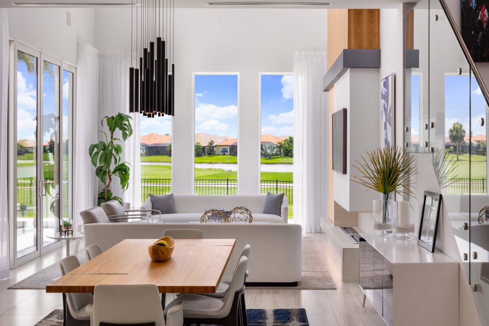 Bright modern living room with tall windows overlooking a golf course